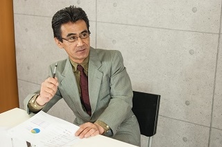 ペンを立てているスーツのおじさん