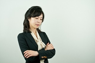 腕を組むスーツ女性
