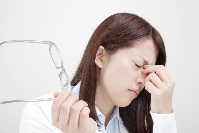 目頭を押さえる女性
