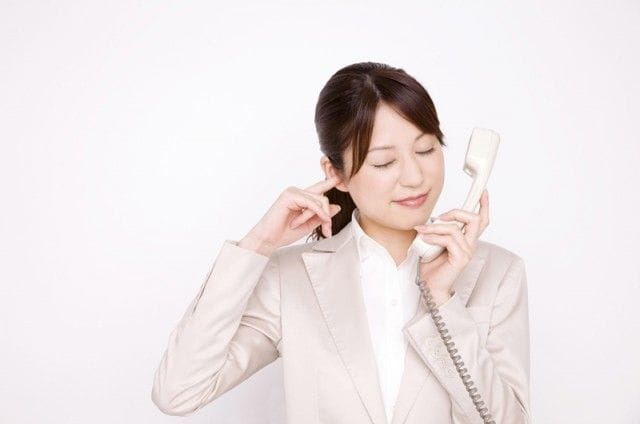受話器を持っているスーツ女性