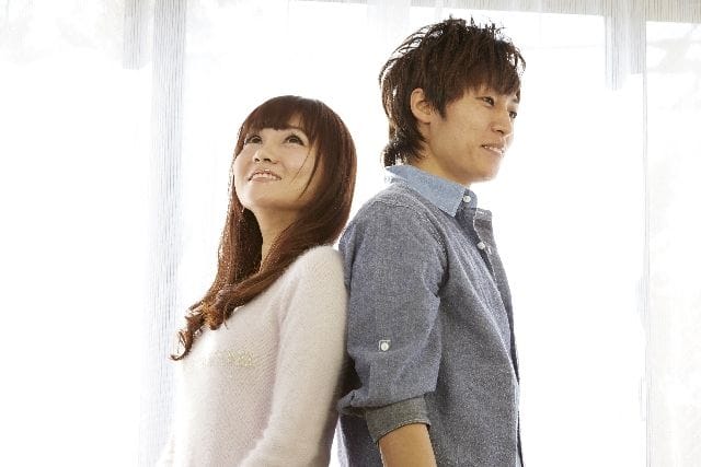 背中合わせになっている男女