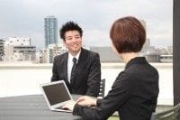外で話すスーツ男女