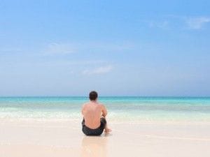 海に一人座る男性