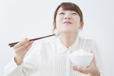 箸でご飯を食べる女性